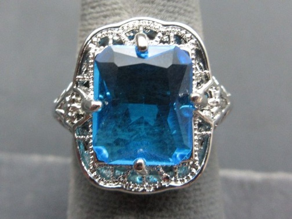 Unmarked silver-tone filigree ring with blue rectangular stone