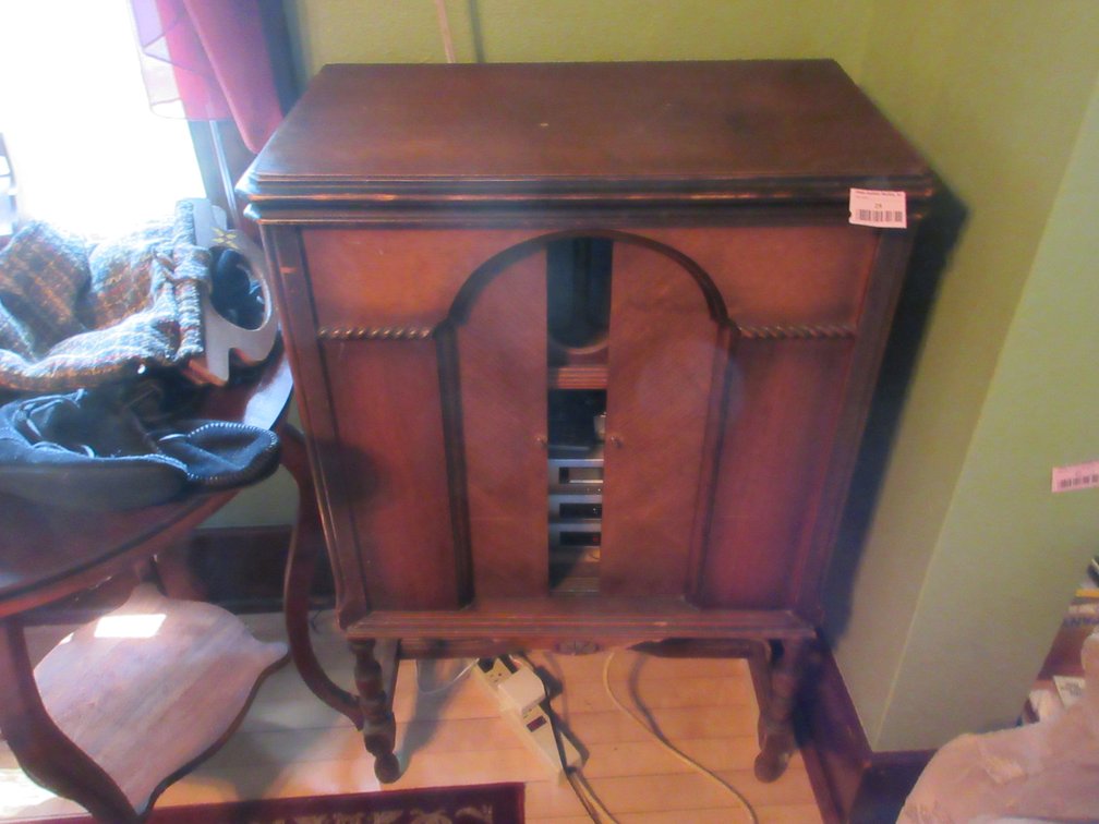 Antique wood stereo cabinet with sliding front doors and small stereo system