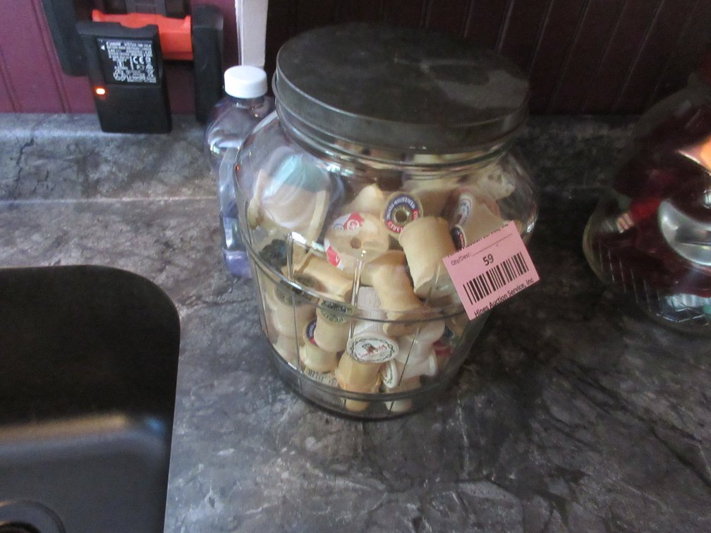 Antique glass jar with wood bobbins