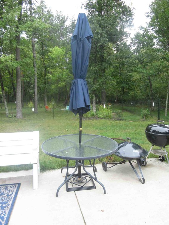 Glass top patio table with umbrella and stand