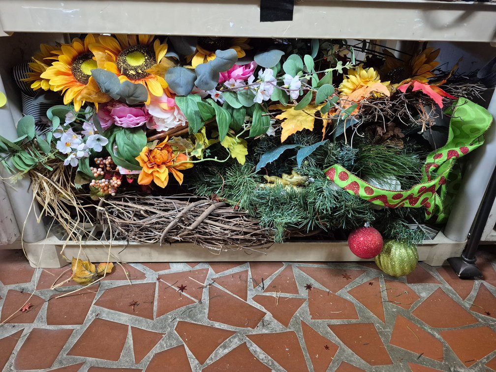 Shelf full of faux flowers, wreaths, greenery+