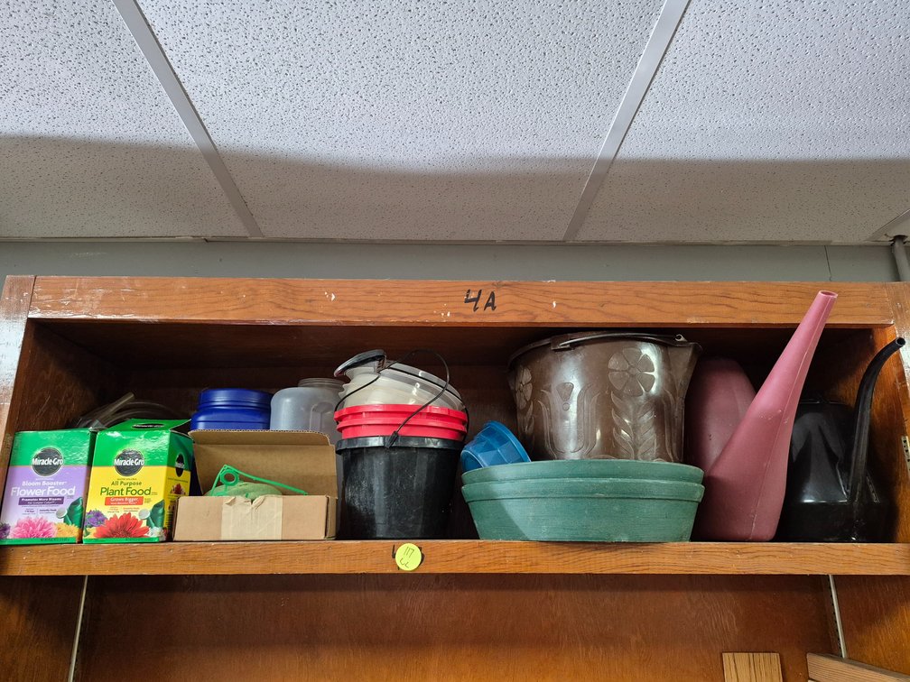 Shelf of planters, watering cans, plant food++