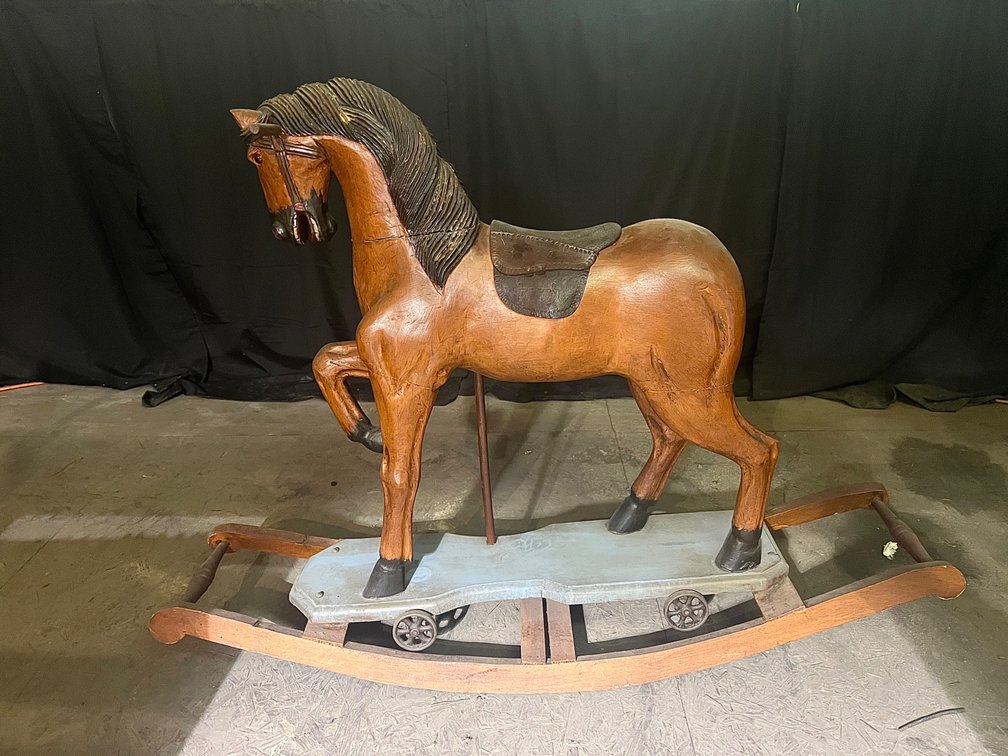 Antique wooden rocking horse with a leather saddle