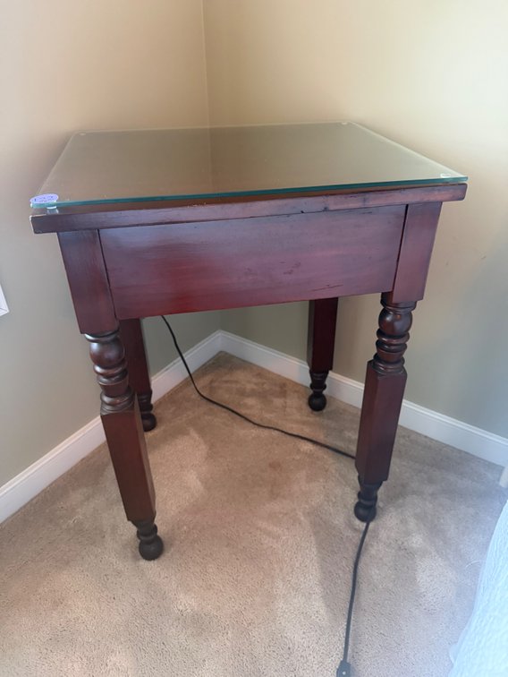 A vintage wooden end table with a dark wood finish