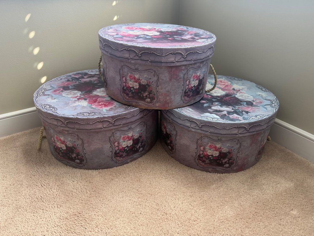 vintage-style round floral hat box with a romantic rose pattern and a braided rope handle