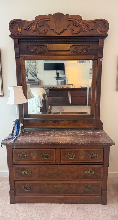 Antique Victorian Eastlake-style burl walnut dresser with a marble top and a large carved mirror