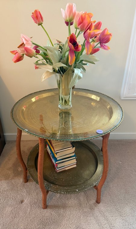 A vintage mid-century two-tier round brass tray table with a folding wood stand