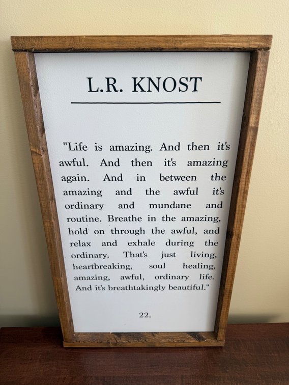 framed wooden wall sign featuring an inspirational quote by author L.R. Knost