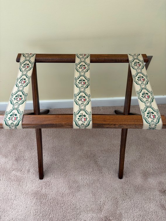 A vintage Scheibe wooden folding luggage rack with patterned floral tapestry straps