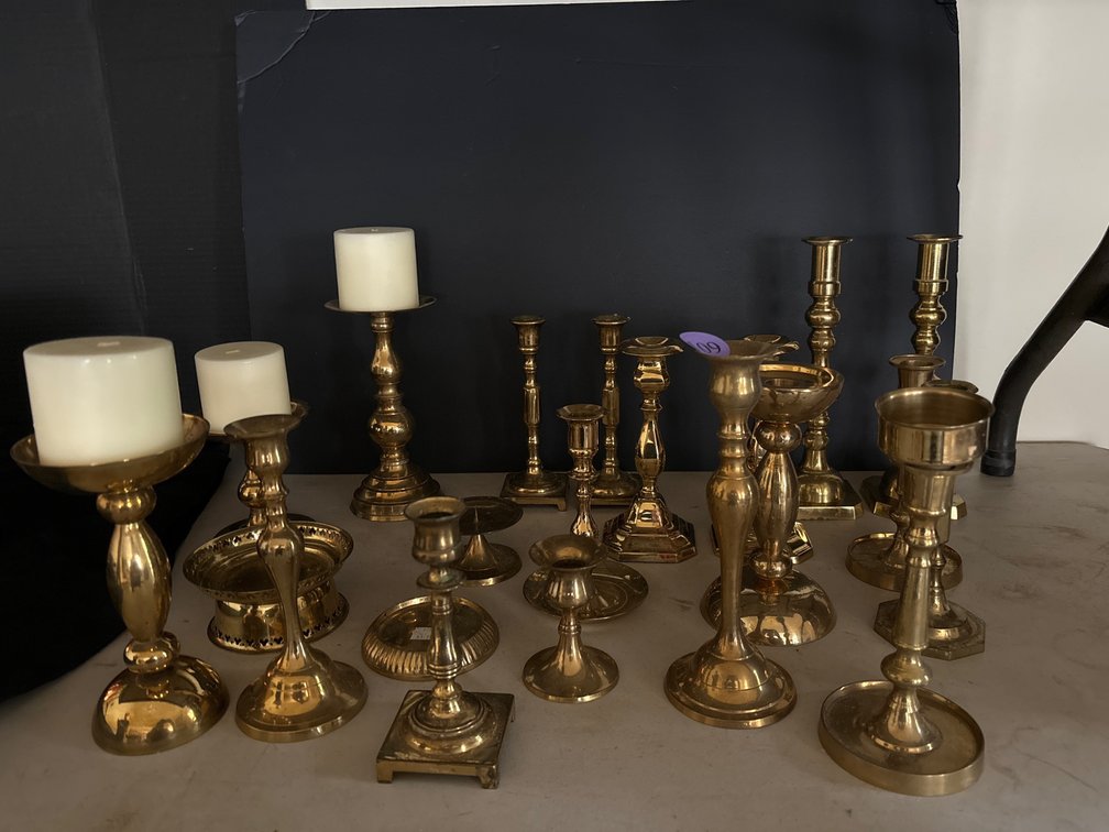 Large assortment of brass candlesticks