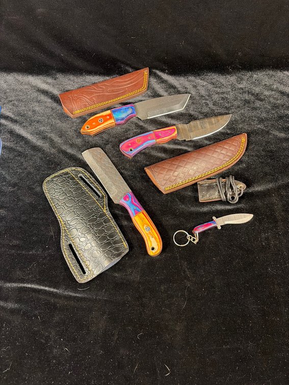 Group of handcrafted knives with leather sheaths