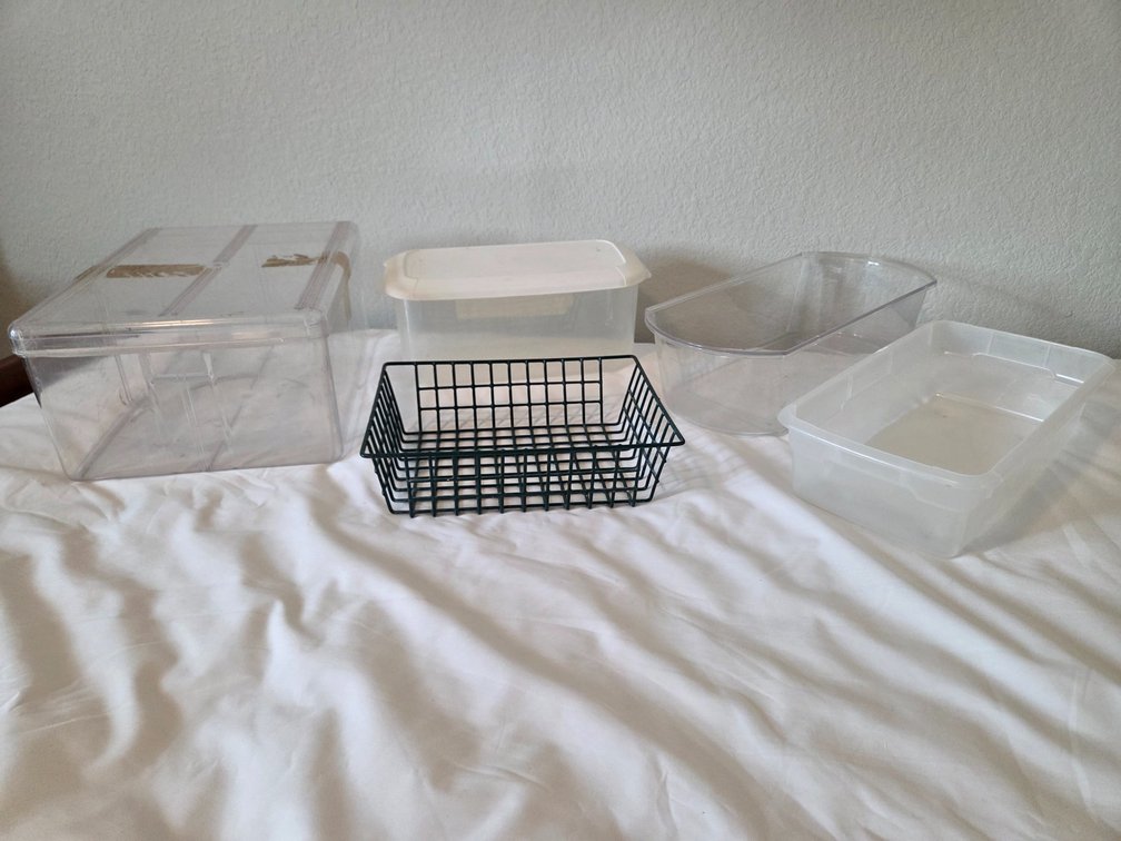 4 plastic home organization bins and one metal green mesh basket