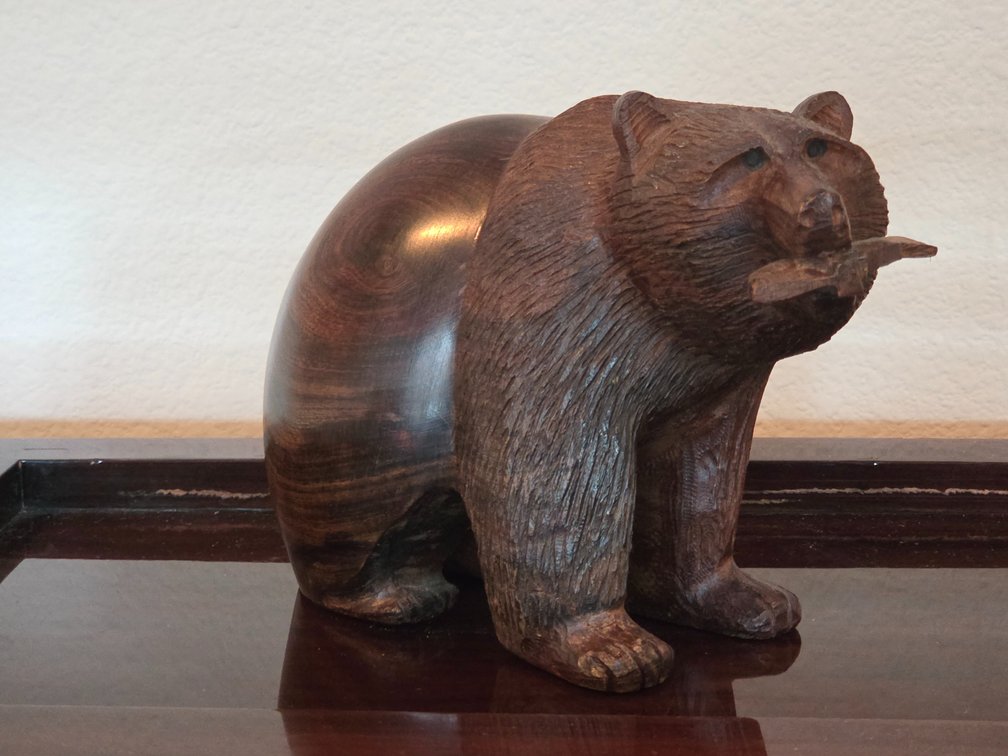 Hand-carved wooden figurine of a bear holding a fish