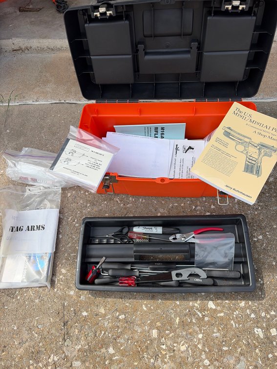 Orange toolbox with gun manuals, and tools