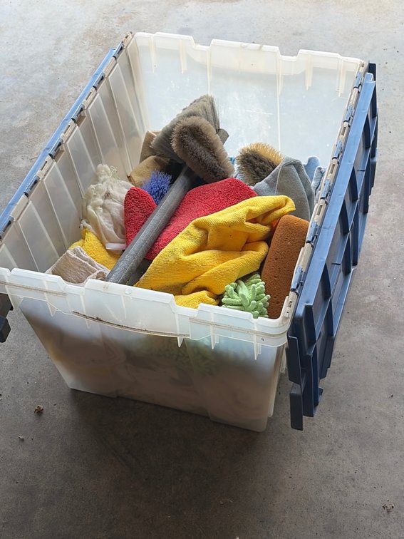 Tub full of cleaning, rags and brushes