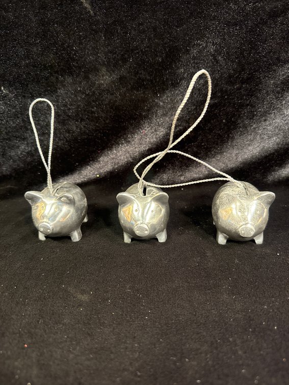 three small silver-colored metal piggy bank or piglet figurines with hanging loops attached as ornaments