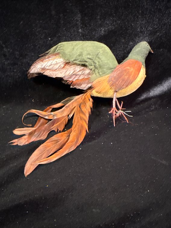 vintage artificial feathered bird ornament with a green head/back, orange-yellow chest, and long brown/orange feather tail streamers with wired feet