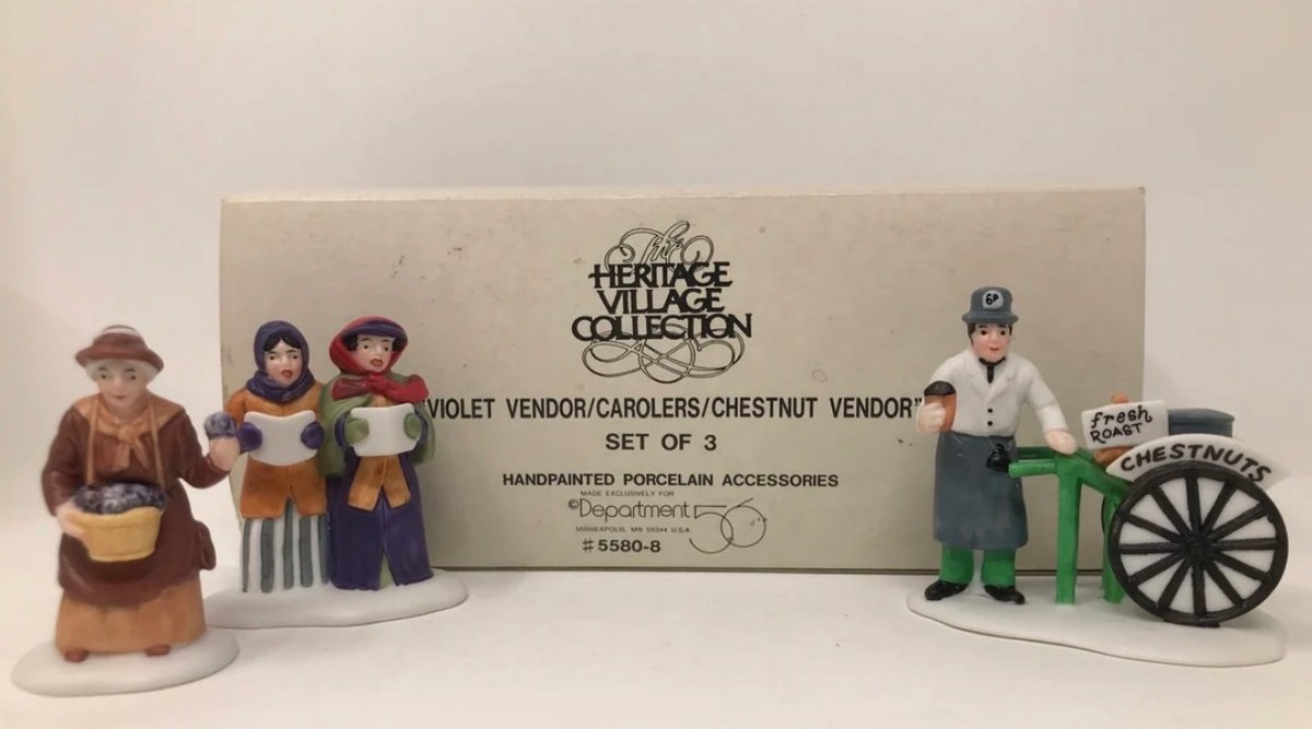 Department 56 Heritage Village Collection set titled "Violet Vendor/Carolers/Chestnut Vendor" (Item #5580-8), which includes a set of three handpainted porcelain accessories