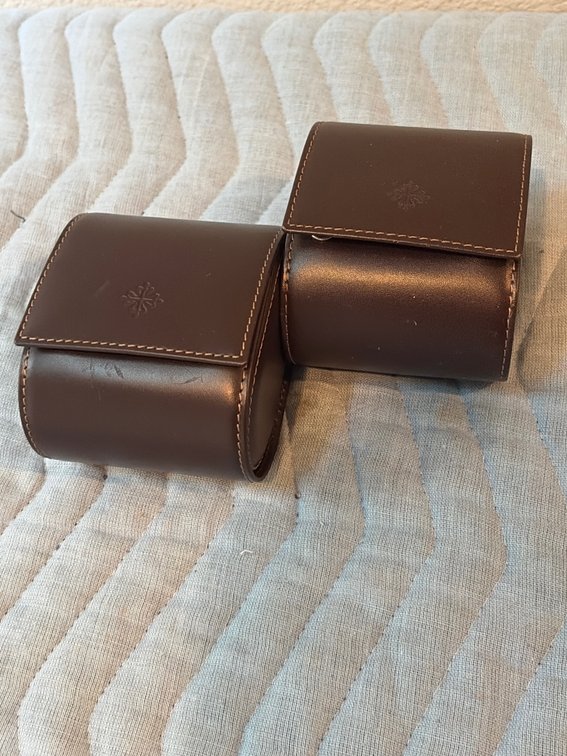 brown leather Patek Philippe travel pouches featuring a distinctive embossed Calatrava cross logo on the front flap