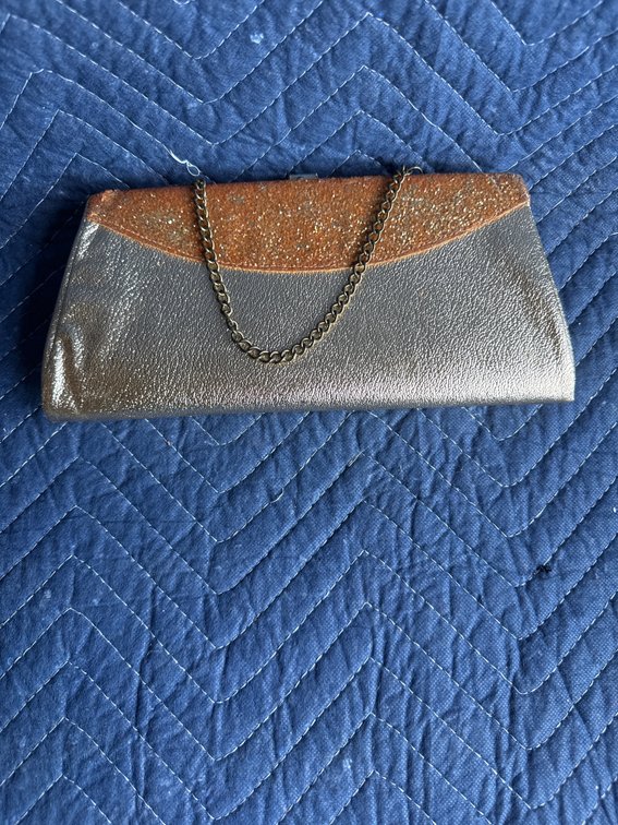 vintage gold and silver metallic evening clutch features a textured gold-glitter flap overlay, a smooth metallic body, and a thin gold-tone chain strap