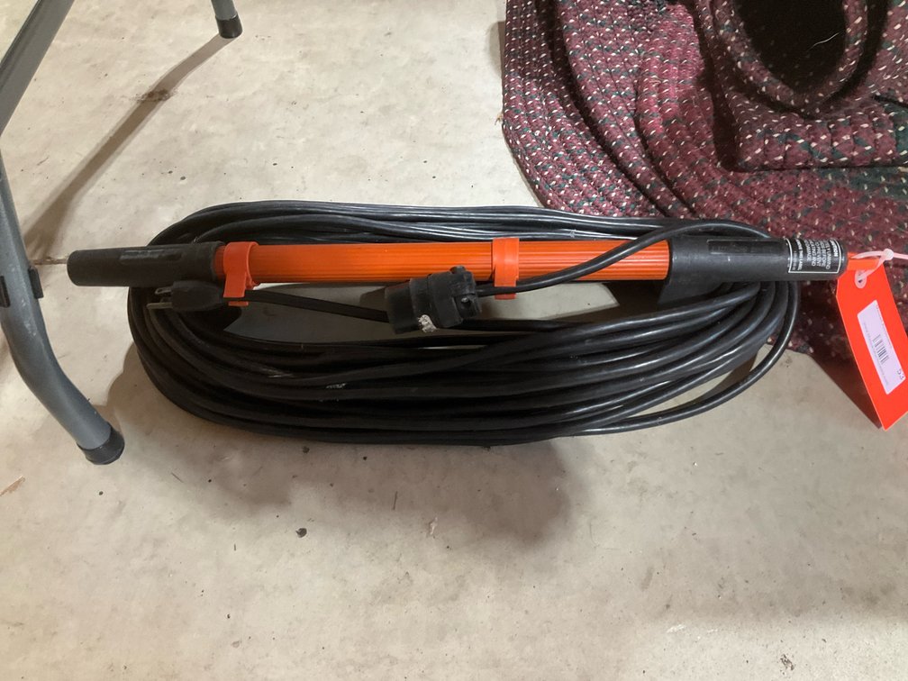 Black extension cord on orange cord storage wrap