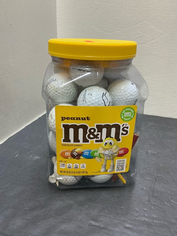 Plastic jar of assorted golf balls & tees