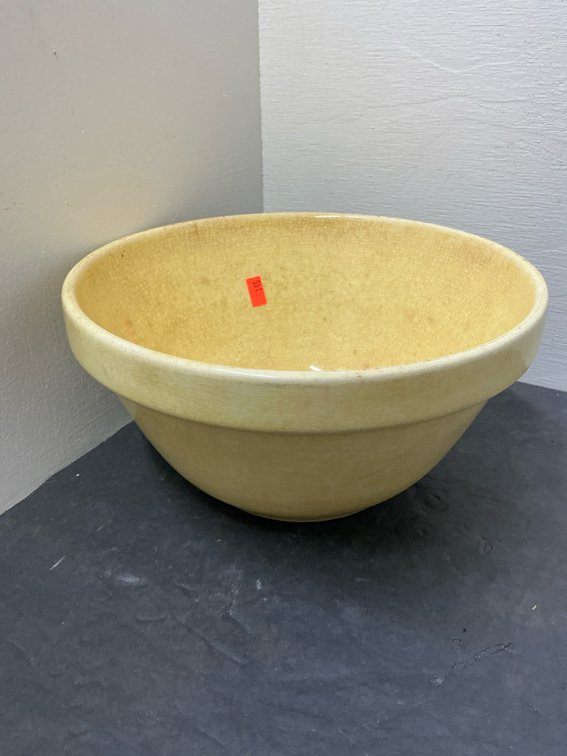Yellow glazed ceramic mixing bowl with projecting rim
