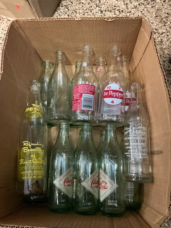 Grouping of clear & green glass soda bottles
