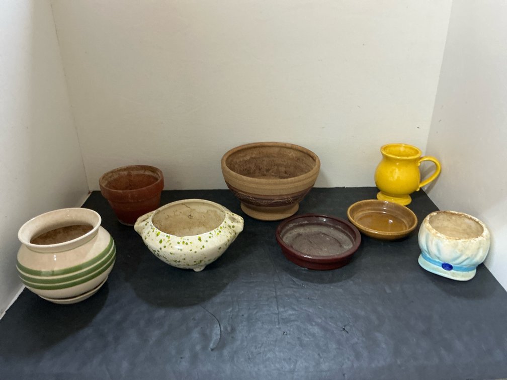 Grouping of ceramic & terracotta planters & saucers