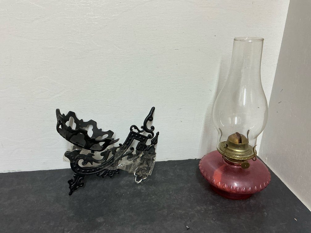Cranberry glass oil lamp with cast iron wall bracket