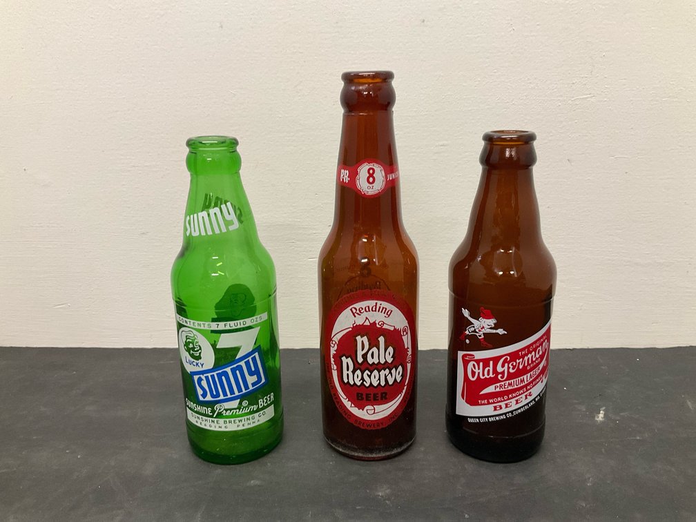 Grouping of  assorted glass beer bottles