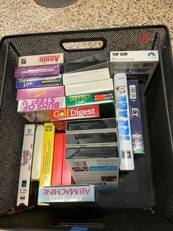 Grouping of VHS & 8-track tapes with wire mesh bin