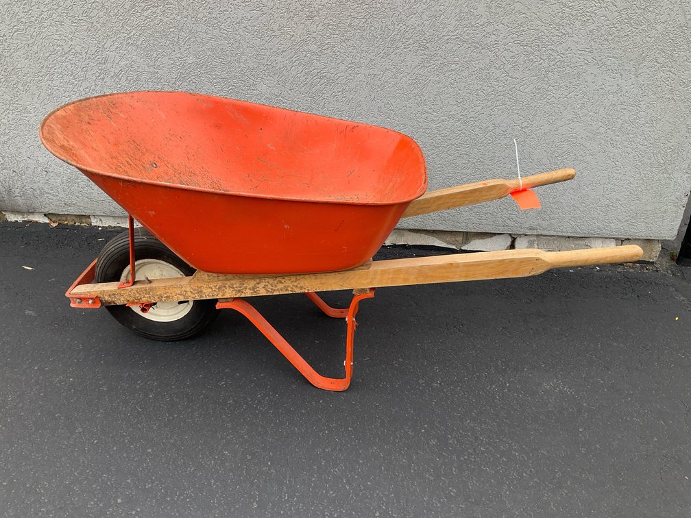 Orange metal wheelbarrow with wooden handles