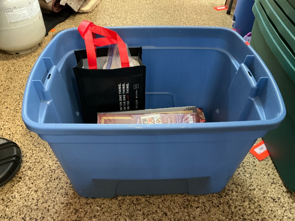 Blue plastic storage tote with household items