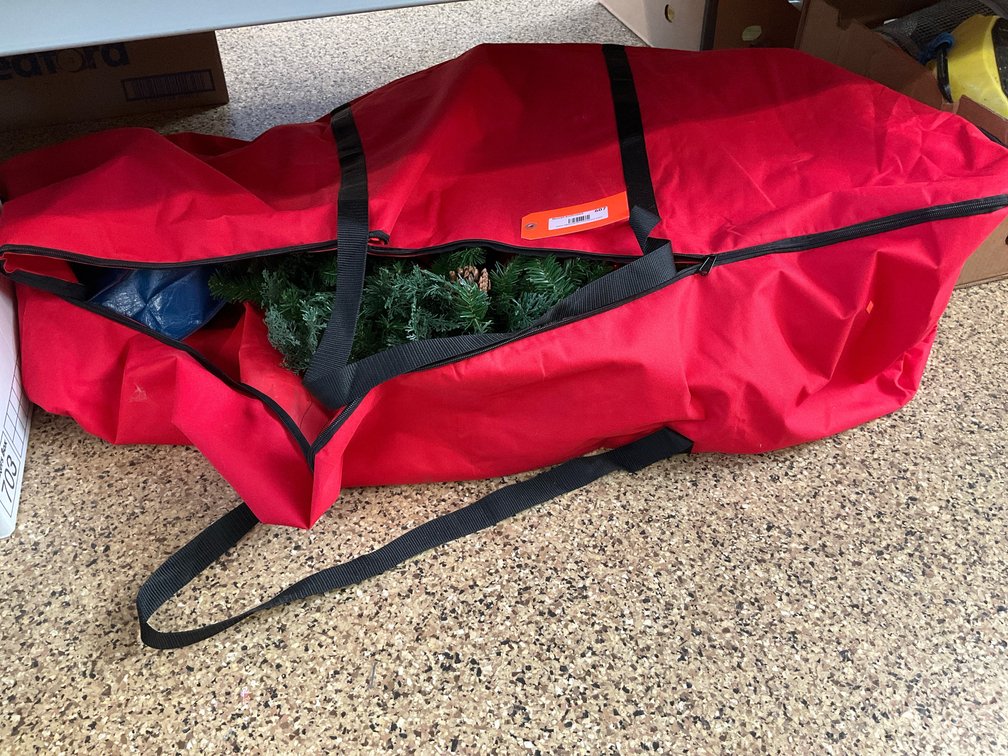 Artificial evergreen wreath with red storage bag