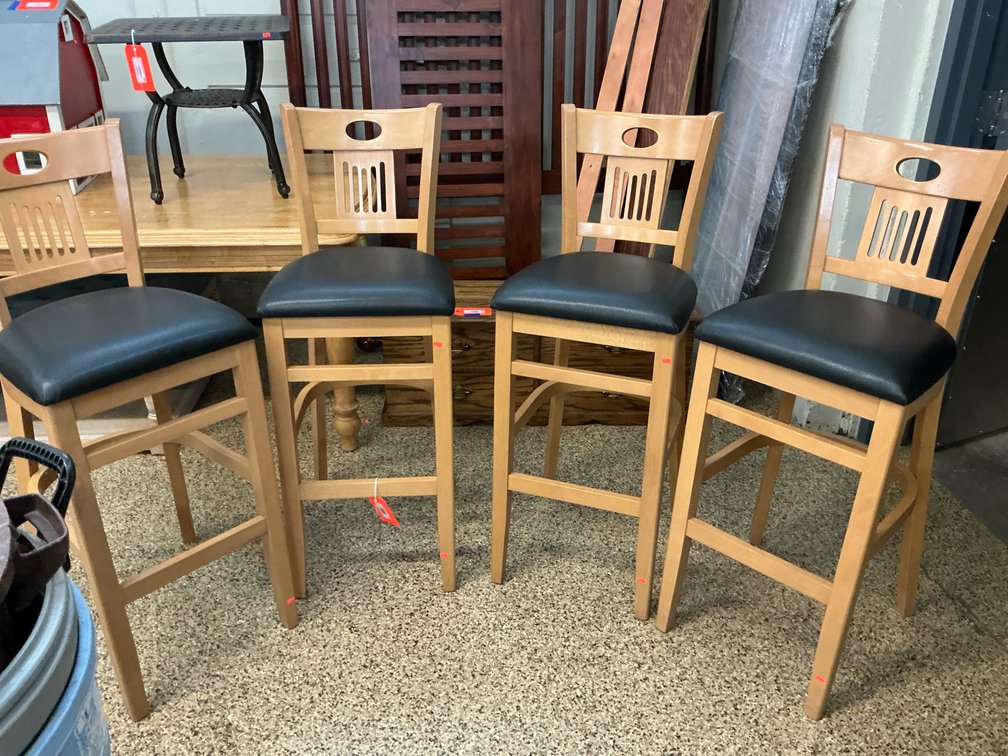 Set of 4 light wood bar stools with black padded seats, 31” seat height