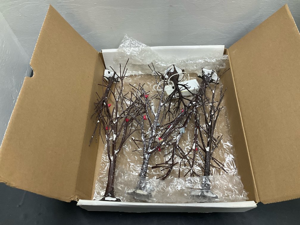 Miniature snow-dusted village trees with red birds