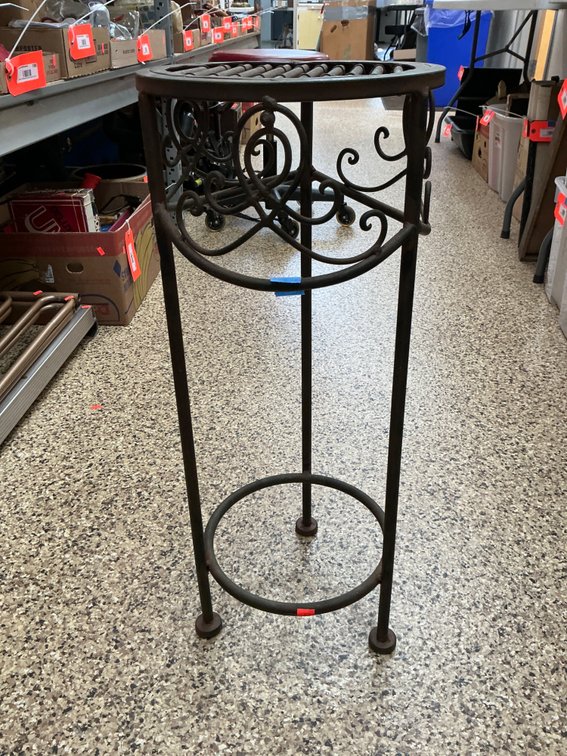 Dark metal plant stand with scrollwork