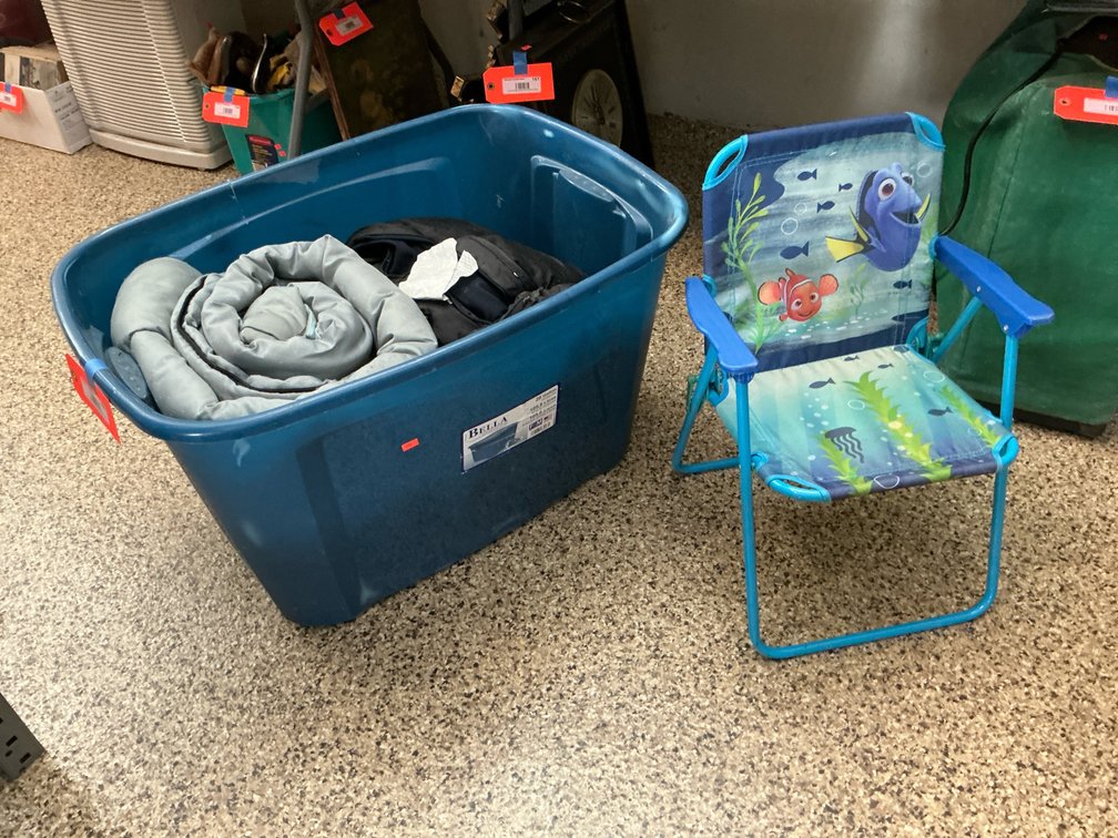 Plastic storage tote with bedding & child's folding chair