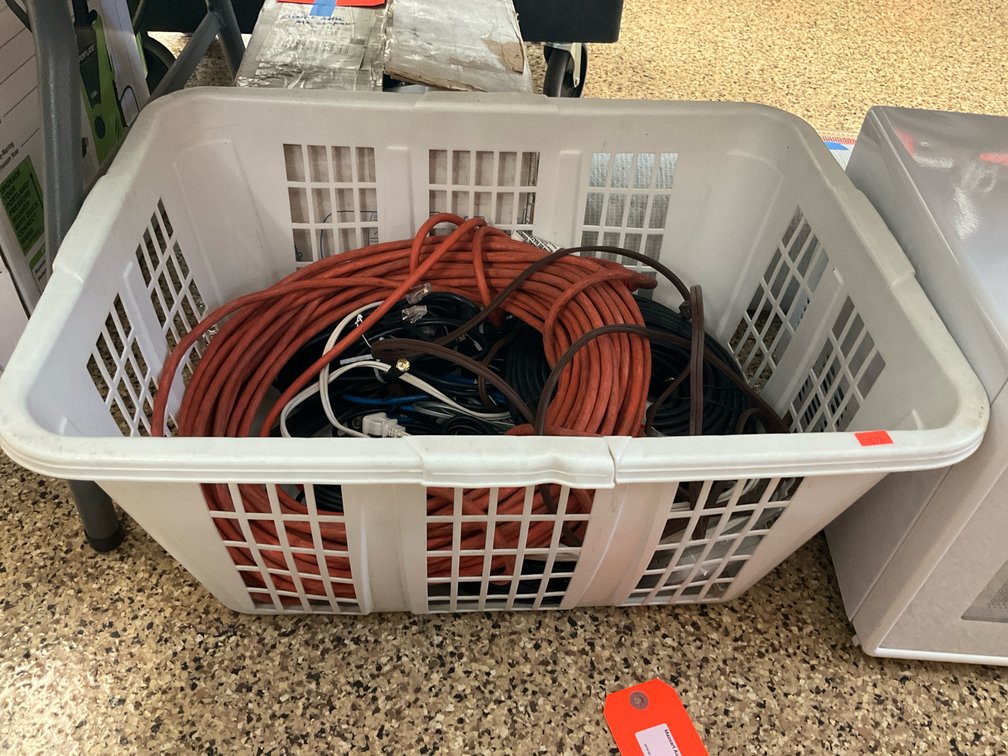 Extension cords & assorted cables in laundry basket