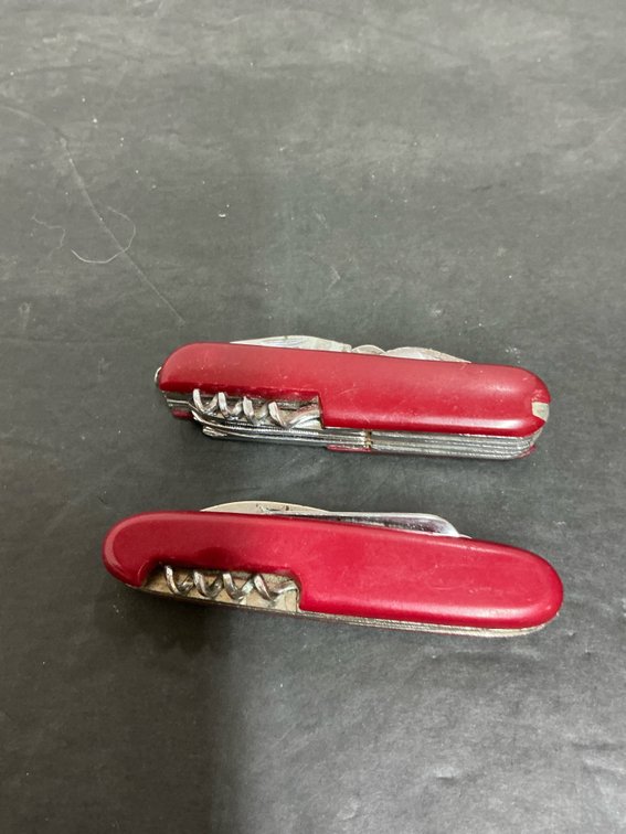 2 red multi-tool pocket knives with corkscrews