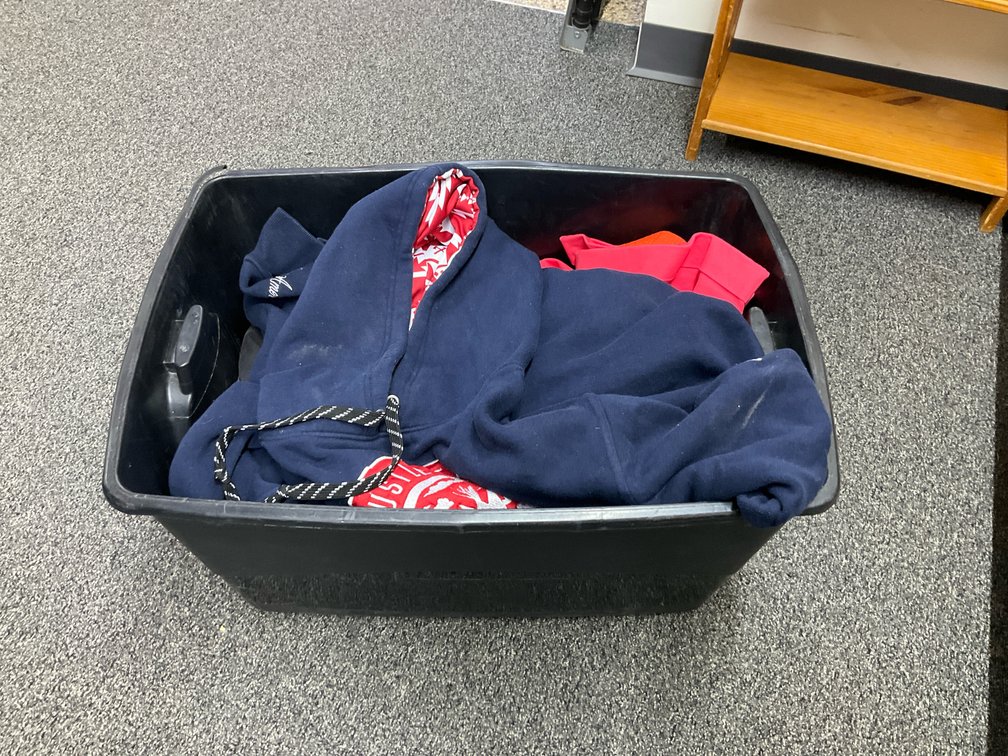 Assorted clothing, jackets & belts with storage tote