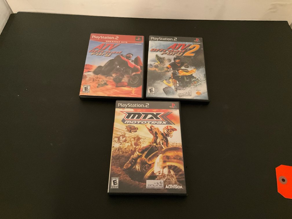 PlayStation racing video games with cases - Basement Living & Bar Area