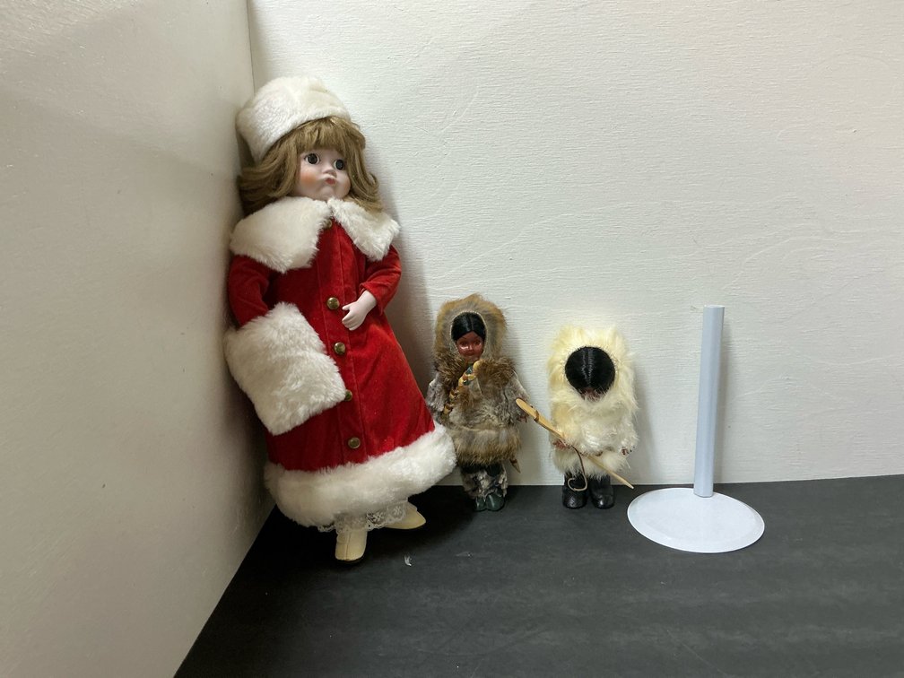 Dolls in winter attire with stand