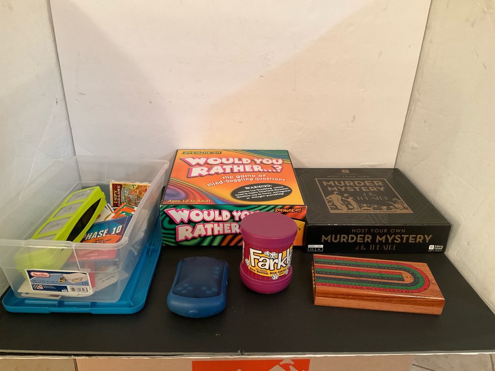 Assorted board & card games with Sterilite storage bin - Basement Living & Bar Area