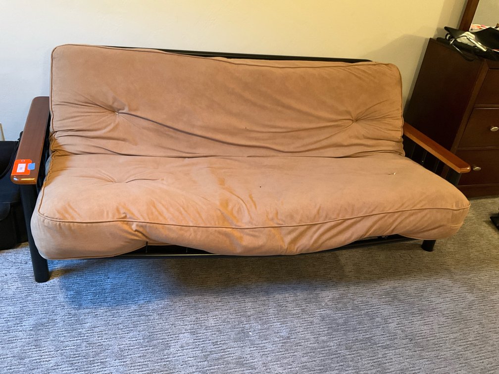 Metal frame futon sofa with wood armrests & tan cushion - Basement Bedroom
