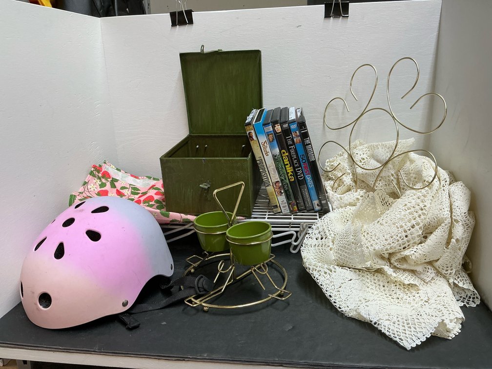 Household grouping with helmet, metal box & DVDs