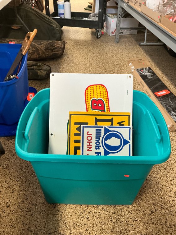 Grouping of agricultural metal signs with plastic tote