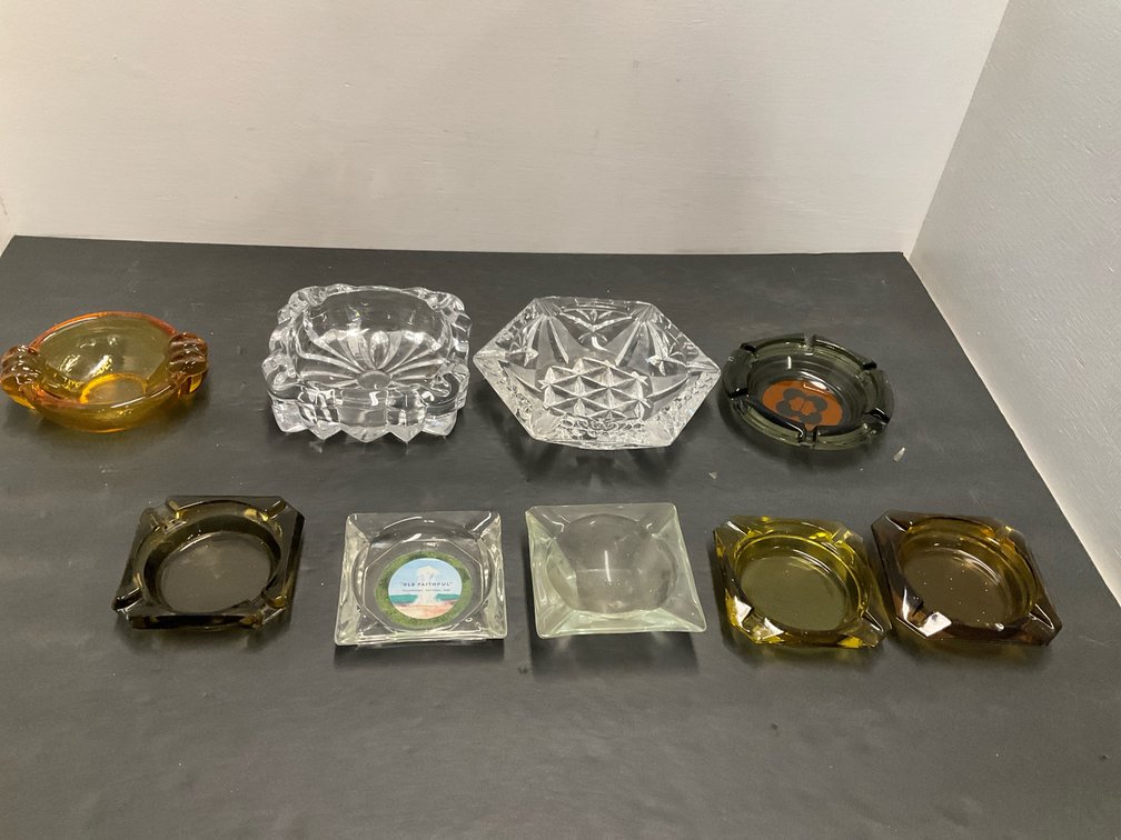 Assorted glass ashtrays in clear, amber & green