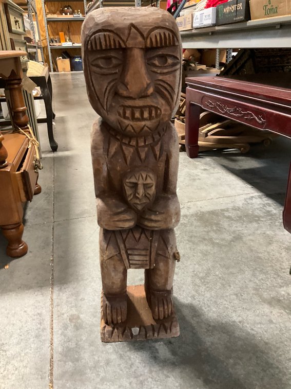 Carved wood tiki-style figure holding head